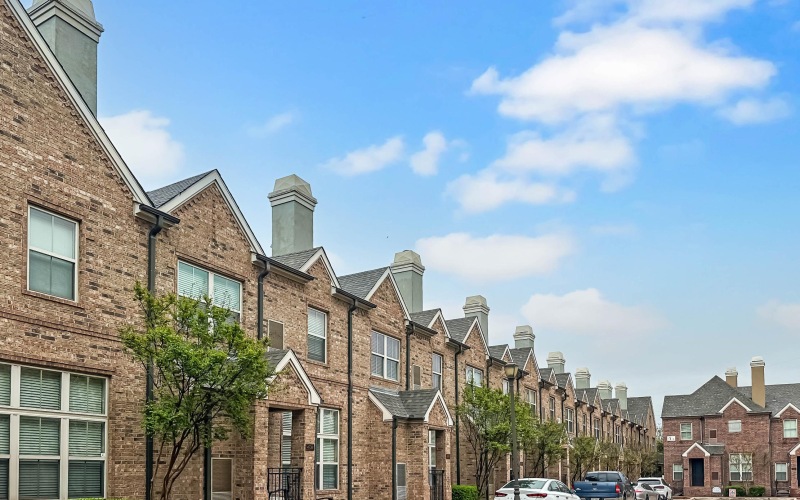 line of brownstone apartments connected with blue skies